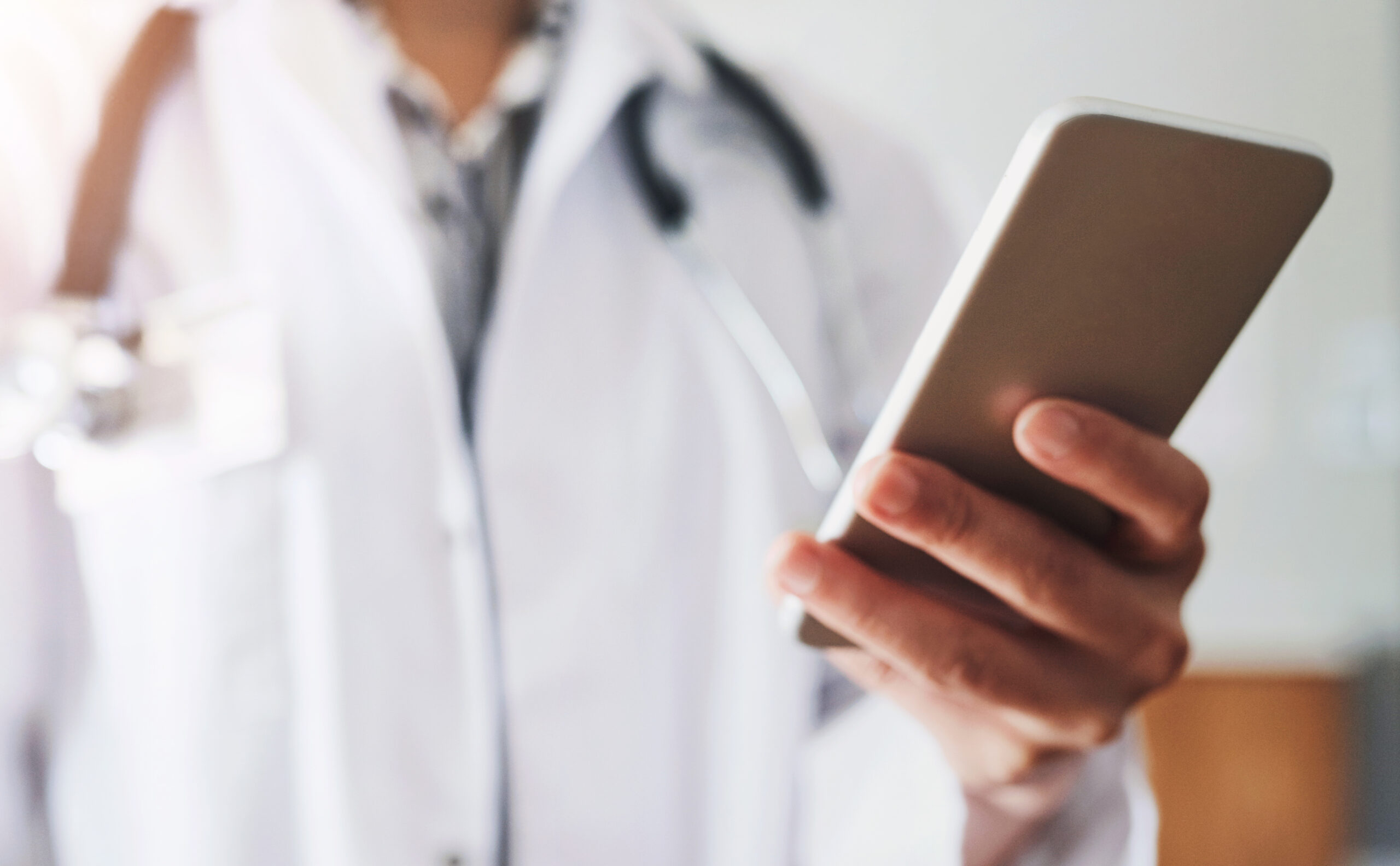 Healthcare, doctor and hand with phone in hospital for medicine research, information and communication. Oncology, professional and person with tech for telehealth, network and online medical news